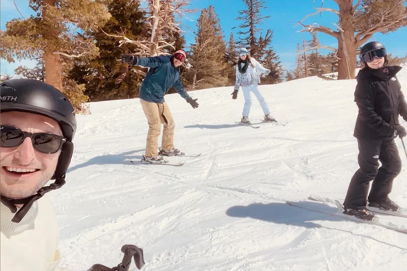 Team members skiing together on a sunny mountain slope