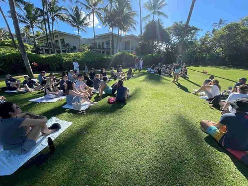 Team sitting in a circle on the lawn during a tropical retreat