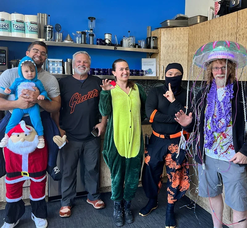 Team dressed in creative Halloween costumes at the office